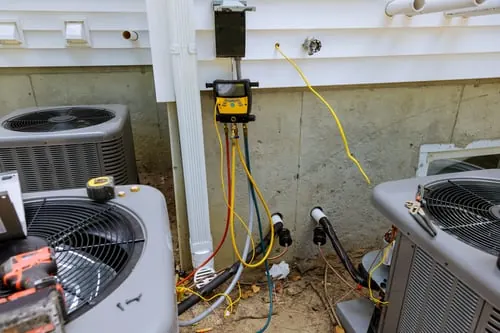 EasyAC Installers technician checking refrigerant pressures on a central A/C system